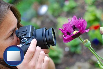 a female photographer photographing a flower close-up - with Colorado icon