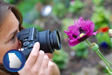 a female photographer photographing a flower close-up - with Georgia icon