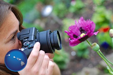a female photographer photographing a flower close-up - with Hawaii icon