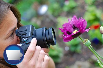 a female photographer photographing a flower close-up - with Iowa icon