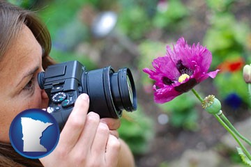 a female photographer photographing a flower close-up - with Minnesota icon