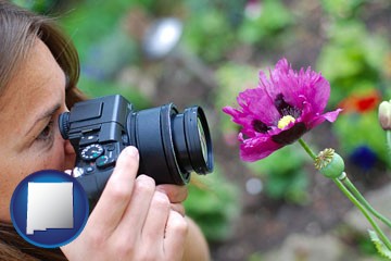 a female photographer photographing a flower close-up - with New Mexico icon