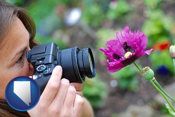 a female photographer photographing a flower close-up - with Nevada icon