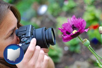 a female photographer photographing a flower close-up - with Ohio icon