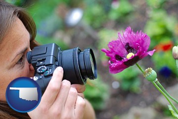 a female photographer photographing a flower close-up - with Oklahoma icon