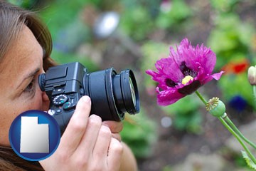 a female photographer photographing a flower close-up - with Utah icon