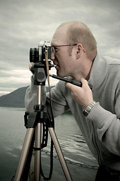 a professional landscape photographer using a camera and tripod