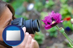 colorado map icon and a female photographer photographing a flower close-up