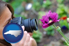 north-carolina map icon and a female photographer photographing a flower close-up