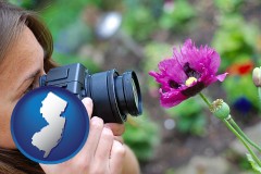 new-jersey map icon and a female photographer photographing a flower close-up