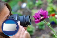 pennsylvania map icon and a female photographer photographing a flower close-up