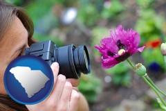 south-carolina map icon and a female photographer photographing a flower close-up